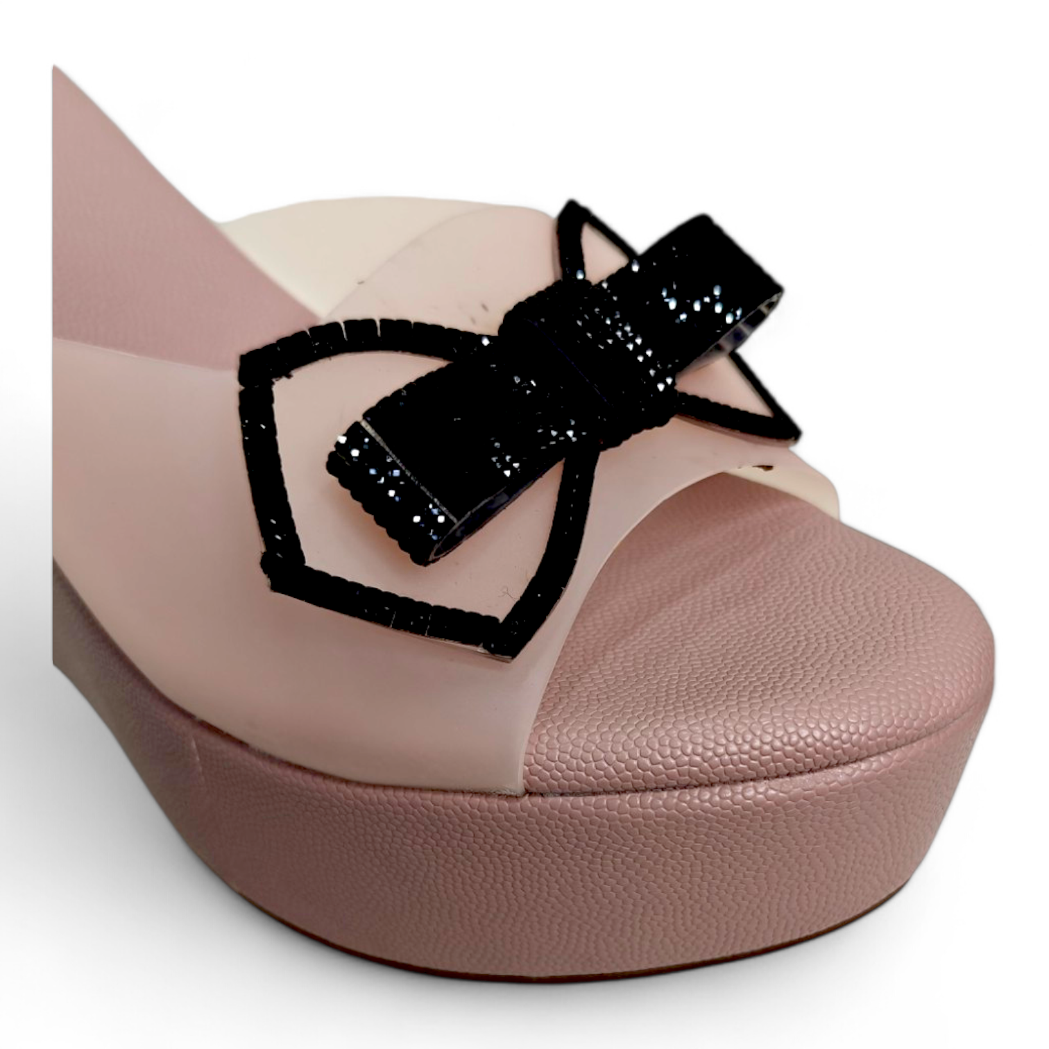 Close-up of embellished bow and transparent belt on peach wedge heel open toe footwear